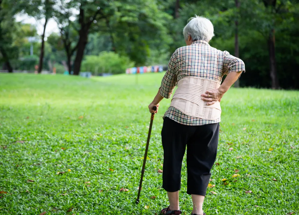 杖をついて歩く年配女性