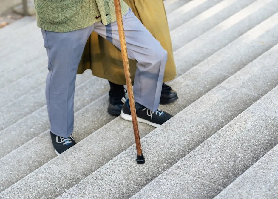 杖をつきながら階段を上る男性