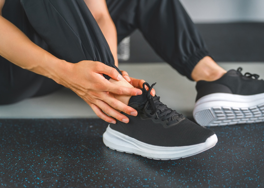 座り込んで靴の様子を見ている男性