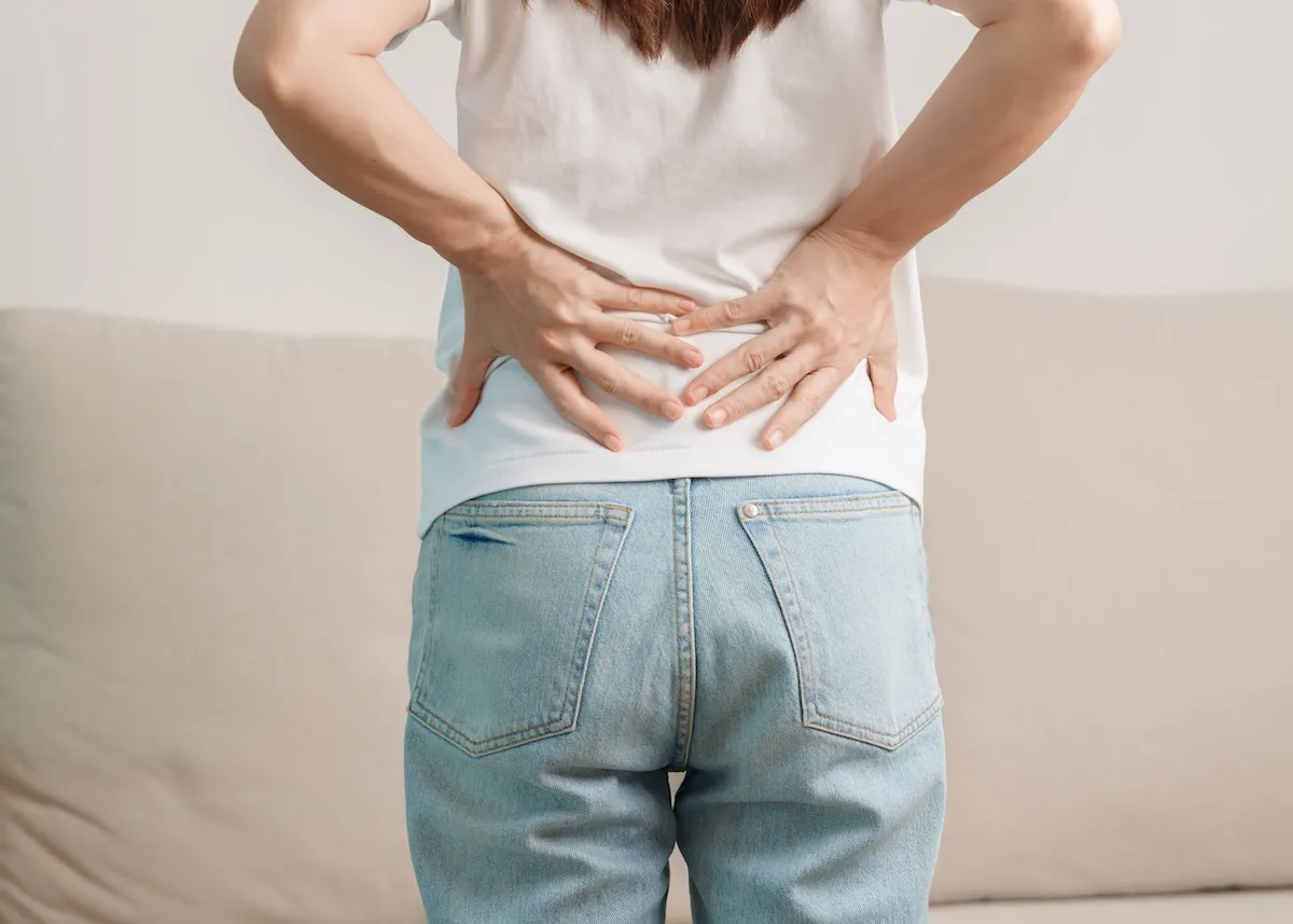 腰に手を当てている女性