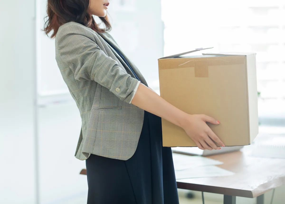 大きな箱を持って歩いている女性