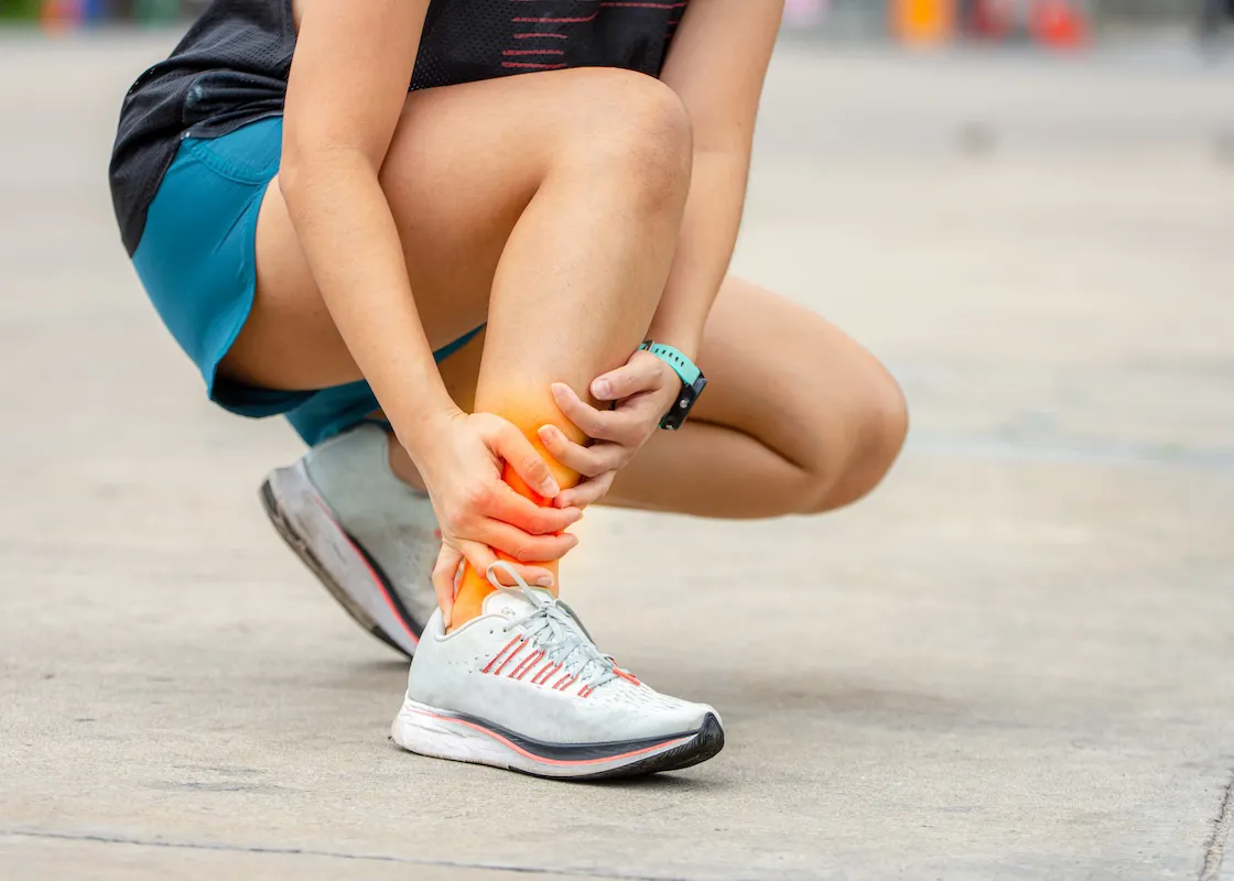 足首を傷めて座り込んでいる女性